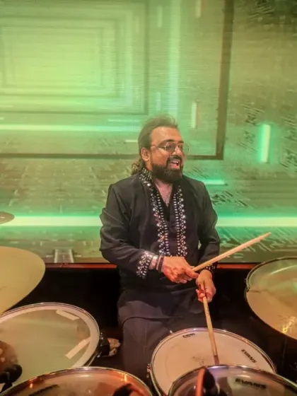 Our drummer, framed by a futuristic stage design, providing the powerful heartbeat of our band.