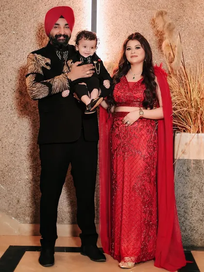 A stunning family portrait from a birthday celebration. Dressed in coordinated outfits, this family of three looks elegant and happy together.