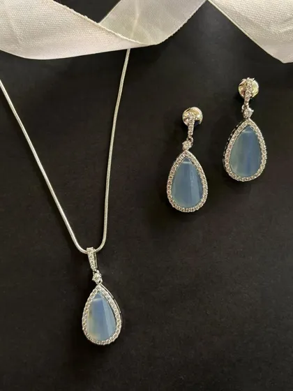 Celebrate the season with timeless elegance. This pendant and earring set, featuring a soft blue stone surrounded by a halo of diamonds, is one of my top festive picks.