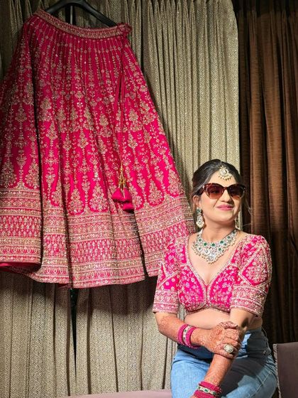 A fun, modern twist on a bridal portrait. The bride pairs her lehenga top with jeans and sunglasses before the ceremony, showing her cool and confident personality.
