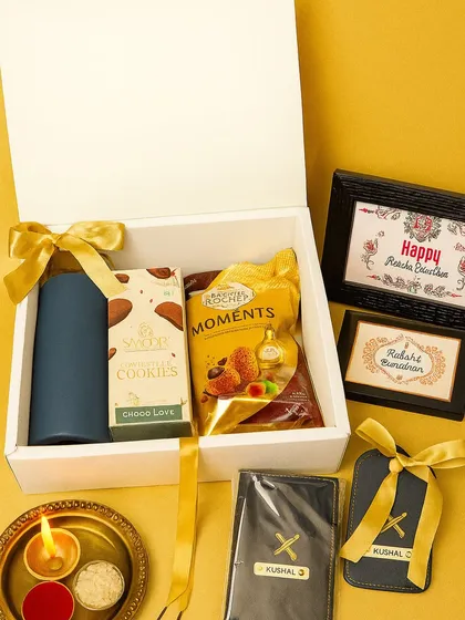 Celebrate the sibling bond with a personal touch. This Raksha Bandhan hamper features personalized passport holders with names, along with premium chocolates and a festive diya, all presented in a classic white gift box.