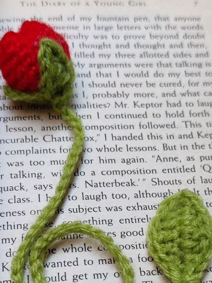 A red tulip bookmark inside a book.