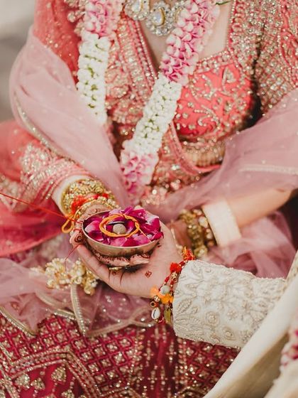 A close-up of the bride's hands during a wedding ritual. We focus on capturing the beauty in the details, from the intricate henna to the sacred traditions being performed.