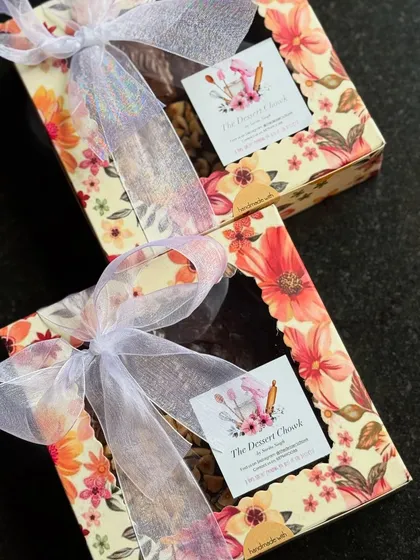 Beautifully packaged brownie boxes for Rakhi. The floral boxes and delicate ribbons make them a special gift for siblings.