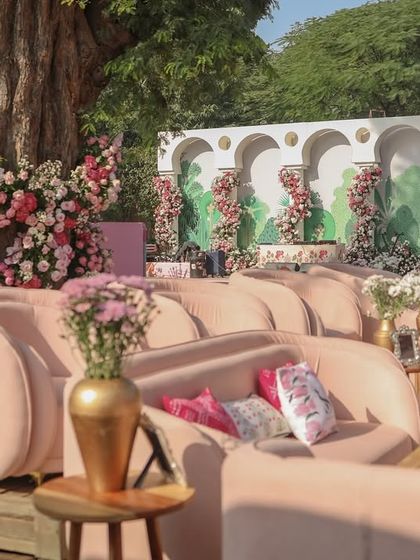 A wider view of the lounge area, showing how the pink furniture and floral-wrapped tree create an inviting and luxurious space for guests.