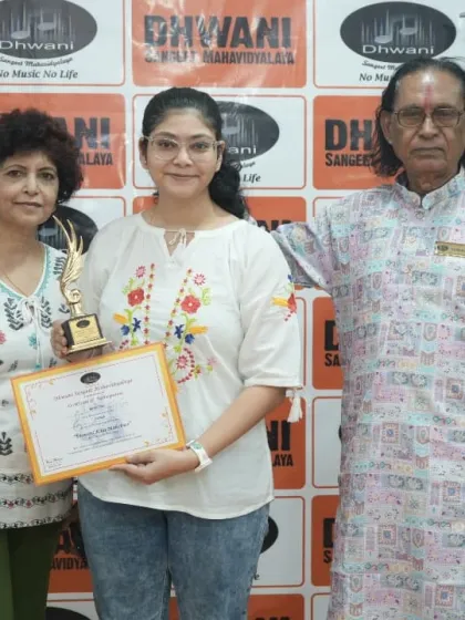 An adult student with her family and our senior guru, celebrating her win.