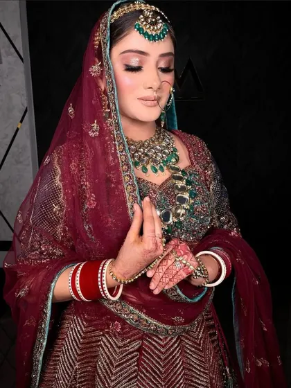 A moment of quiet contemplation. The intricate details of the jewellery, from the necklace to the nath, are beautifully captured.