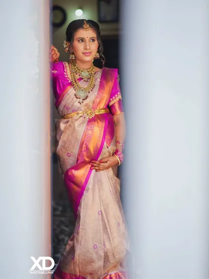 A beautifully framed portrait of the mother-to-be during her baby shower, captured through a doorway to create a sense of intimacy and anticipation.