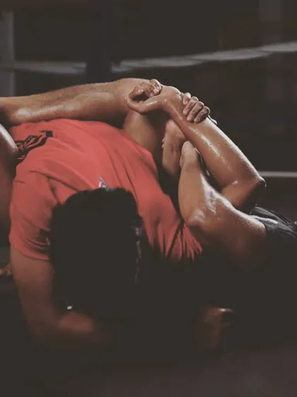MMA is human chess, and our Brazilian Jiu-Jitsu training is where you learn the strategy. This image shows a live grappling session, focusing on control and submission techniques from the guard position.