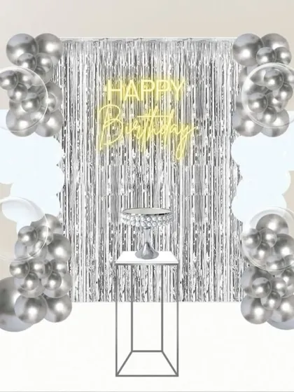 This is how we plan your perfect party. I create detailed mockups like this one, showing a silver-themed birthday setup with a neon sign, balloon columns, and a cake stand, so you can visualize and approve the design before the event.