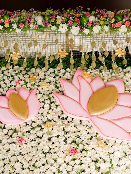 A detailed shot of the floral wall, showing the texture of the white chrysanthemum base and the placement of the pink and gold lotus accents. Our focus on detail ensures every angle is picture-perfect.