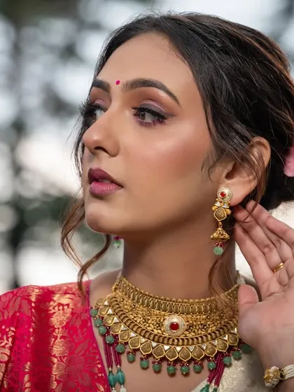Another elegant profile shot, capturing the details of the jewelry and the floral hair accessory.