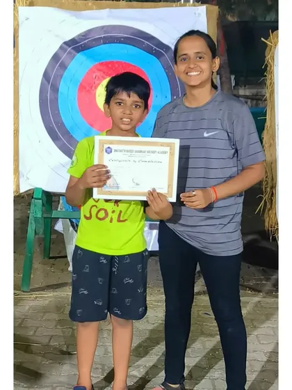 This young student proudly displays his certificate. He was one of the most improved archers in the camp.