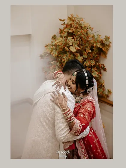 A tender hug between the bride and groom, a quiet moment of connection and reassurance amidst the grandeur of the wedding ceremony.