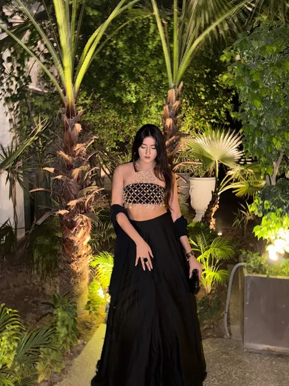 Posing against a backdrop of palm trees, the black outfit looks incredibly chic and party-ready.