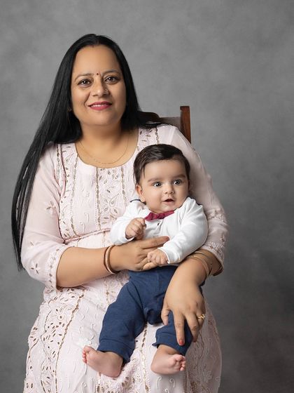A classic portrait of a grandmother holding her sweet grandbaby. Her gentle smile and the baby's calm expression make for a serene and loving image.