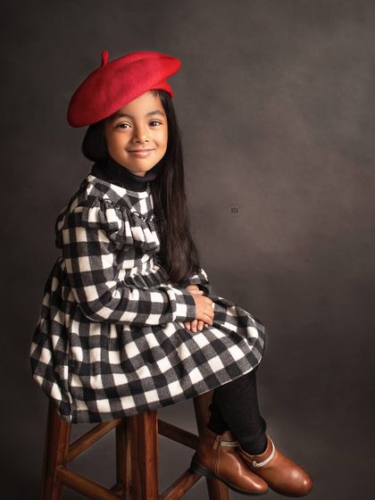 A sweet, seated portrait from the Parisian-themed shoot. Her gentle smile and stylish outfit are perfectly chic.