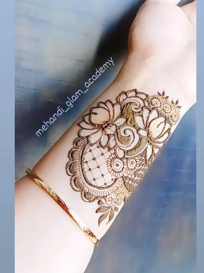 A beautiful lotus patch design on the wrist, combining flowers, swirls, and a checkered filler pattern.