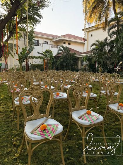 Another view of the guest seating with traditional hand fans, set against the backdrop of a beautiful garden wedding.