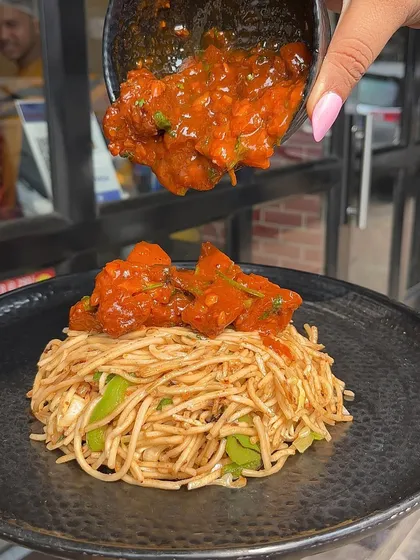 A close-up of the sauce being poured over my Chaupal Noodles. The rich gravy coats every strand of noodle, ensuring a flavourful bite every time.