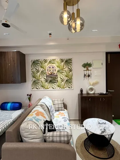 This living room has a cozy, natural feel with a leaf-patterned wallpaper behind the mandir. I used a mix of seating, including a sofa and a diwan, to provide flexible options for the family.