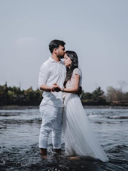 A romantic pose in the water. The flowing white dress and the gentle embrace create a beautiful, almost ethereal image for this riverside pre-wedding shoot.