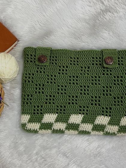 A flat-lay of the green and white checkerboard iPad sleeve. It features wooden buttons for a rustic, secure closure.