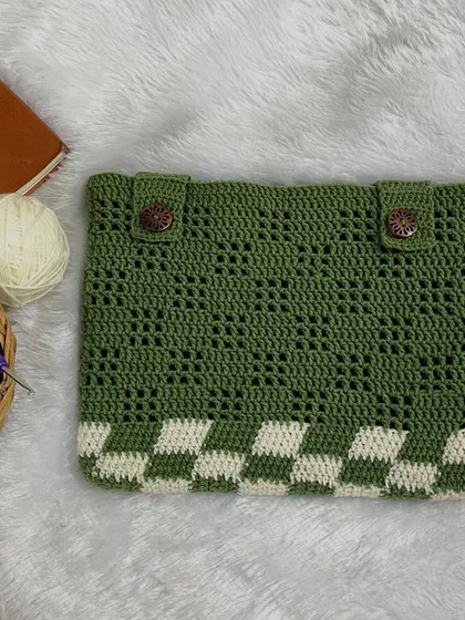 A flat-lay of the green and white checkerboard iPad sleeve. It features wooden buttons for a rustic, secure closure.