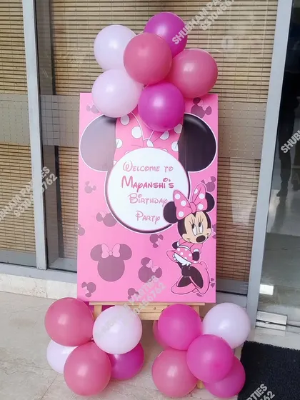 A cute welcome board for a Minnie Mouse themed birthday party, complete with pink balloons.