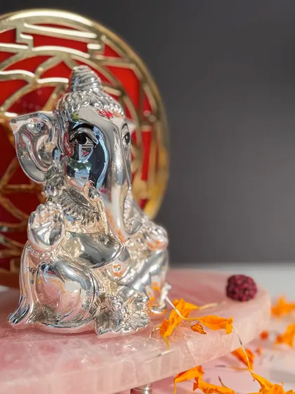 A detailed close-up of my silver-plated Ganesha idol, showing the fine craftsmanship in his eyes and the sacred tilak on his forehead.