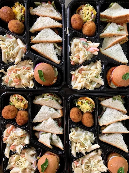 Ready-to-eat meal boxes for a movie party, featuring a mix of sandwiches, pasta salad, and starters.