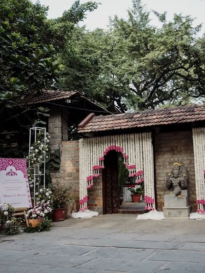 The grand entrance decorated with strings of jasmine and pink flowers, creating a fragrant and beautiful welcome for wedding guests.