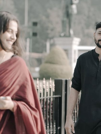 A candid, motion-filled shot of a couple walking on a city street, capturing a natural and happy interaction.
