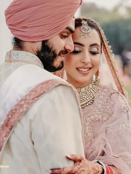 A tender and loving portrait of the Sikh couple. The groom's gentle embrace and the bride's happy smile create a moment of pure, serene love.