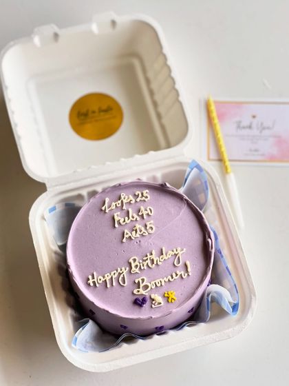 A playful "Happy Birthday Boomer!" message on a lovely lavender bento cake. I can add small, custom details like the tiny cat and dog figures to match an inside joke.