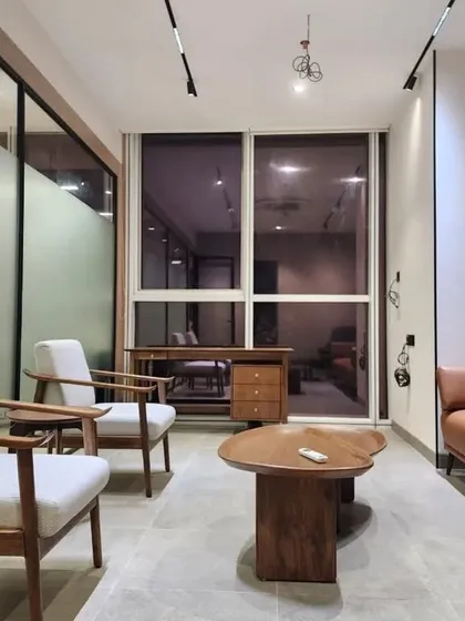 For this office lounge area, I provided the mid-century modern armchairs, the leather sofa, and the custom-shaped wooden coffee table. My work isn't just for homes; I also create comfortable and stylish furniture for commercial waiting areas and lounges.