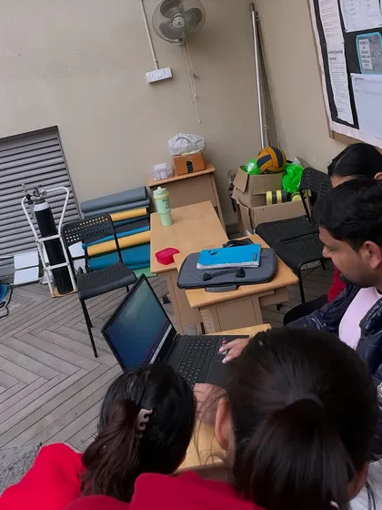A group of swimmers gathered around the laptop for a video analysis session. We foster a collaborative environment where athletes learn not only from my feedback but also by observing and understanding the techniques of their teammates.
