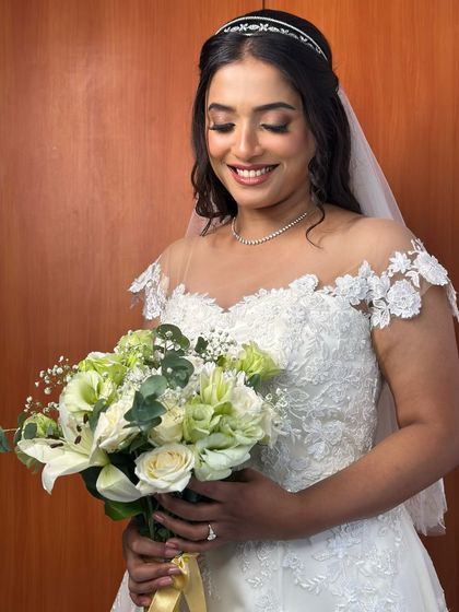 A beautiful, smiling portrait of the bride, her soft makeup and romantic curls perfectly complementing her lace gown and delicate veil.