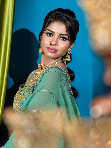A slightly different angle of the semi-traditional look, this shot offers a clear view of the makeup and jewelry. The soft foreground blur adds a touch of artistry and depth.