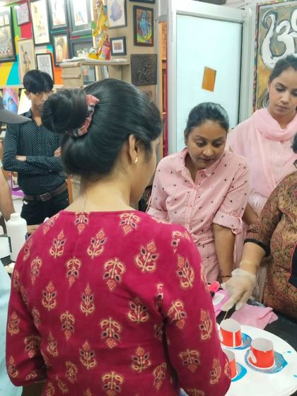 A group of students watching a live demonstration of resin pouring techniques, learning together in a collaborative environment.