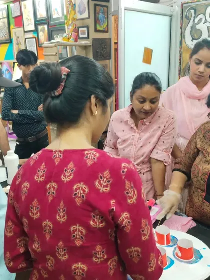 A group of students watching a live demonstration of resin pouring techniques, learning together in a collaborative environment.