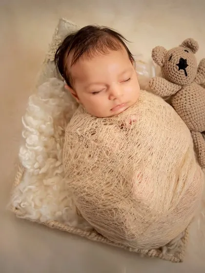 Pure and simple. A neutral-toned swaddle and a little teddy bear friend are all that's needed to create a heartwarming and classic portrait of your newborn baby boy.