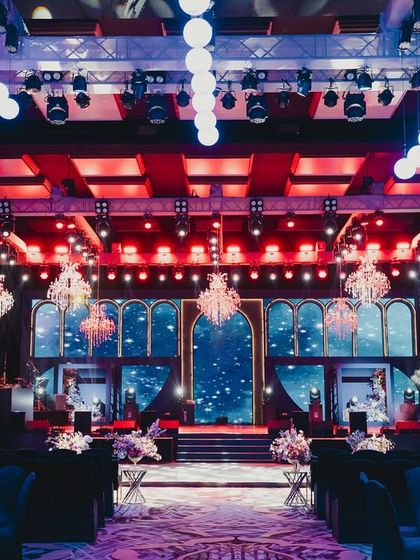 A wide view of a grand Sangeet hall, where the stage design, lighting, and seating are all meticulously planned to create a cohesive and dramatic world for an evening of performances.