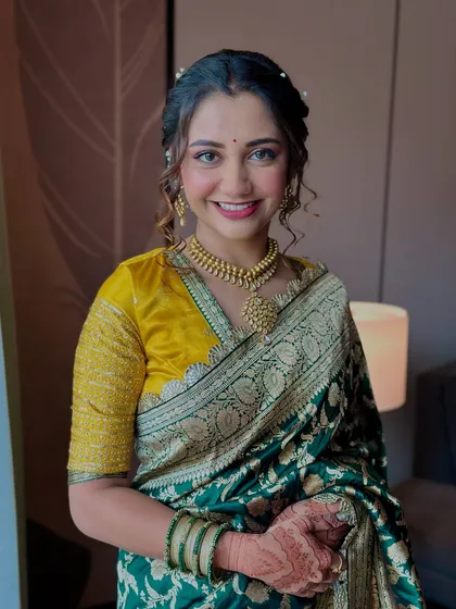 A classic portrait of the bride. Her makeup is minimal and clean, focusing on a flawless base and a pretty pink lip that complements her saree.