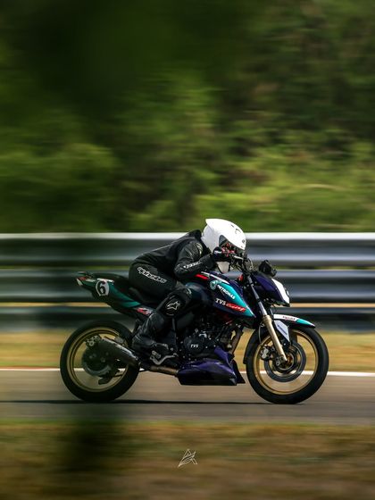 Poojita AK, one of our rising stars, blurs past the trackside scenery on her TVS RTR 200. This panning shot captures the sheer speed she carried to secure a double podium finish at the INMRC 2025 season opener.
