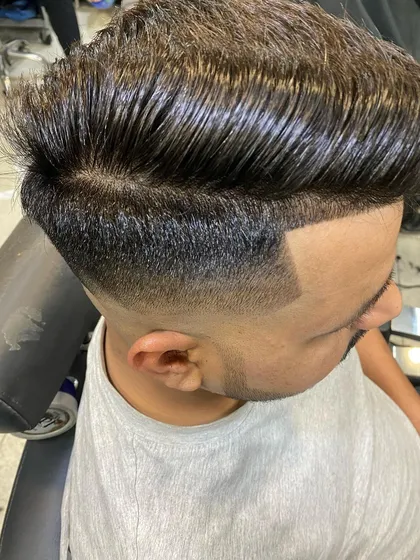 A classic haircut with a side part and a gentle taper. The hair is styled for a wet look, giving it a sharp, defined texture.