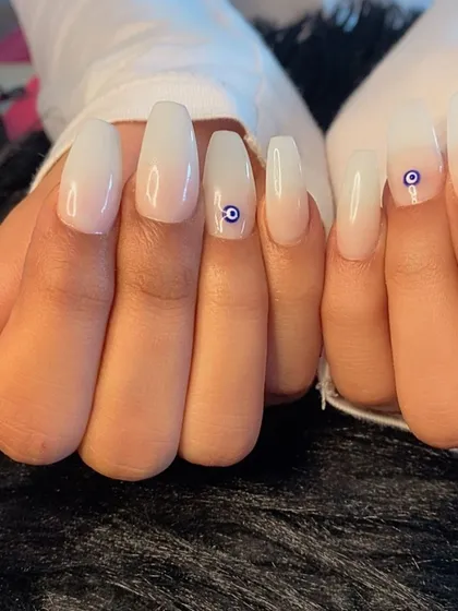 A milky white base with a simple evil eye charm for a touch of protection and style.