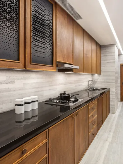 Our approach to kitchen design is rooted in functionality and refined craftsmanship. The custom teak cabinetry in the Limestone Residence, paired with a sleek granite countertop and limestone walls, demonstrates our focus on durable, natural materials and clean lines.