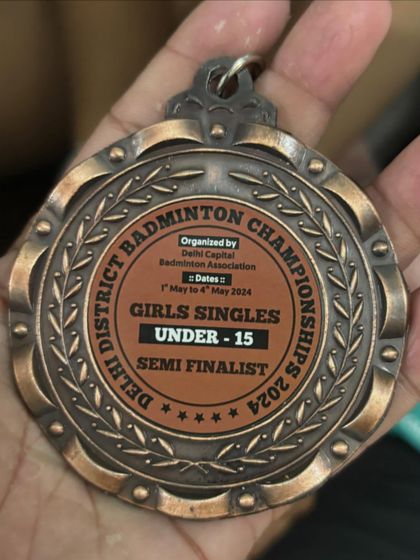 A close-up of the bronze medal from the New Delhi District Badminton Championship. Every medal tells a story of dedication.