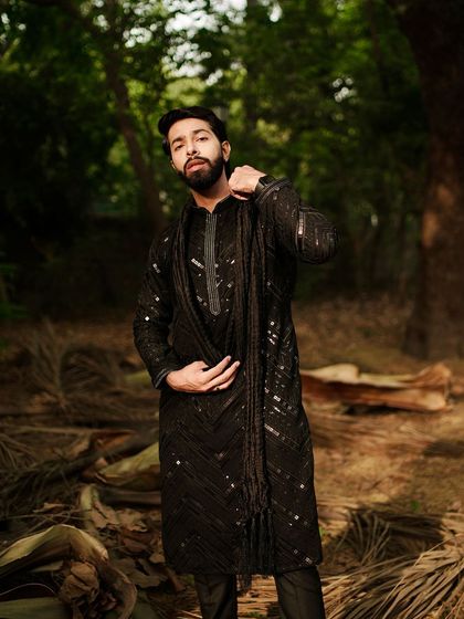 A full-length shot of the black sequined kurta. This is Indian menswear that combines a Bollywood look with modern wearability.